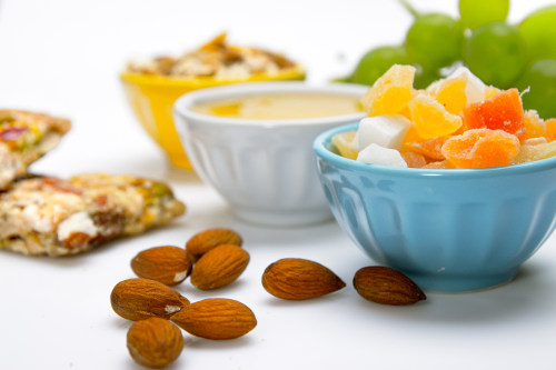 photograph that shows almond nuts and bowl with fruits